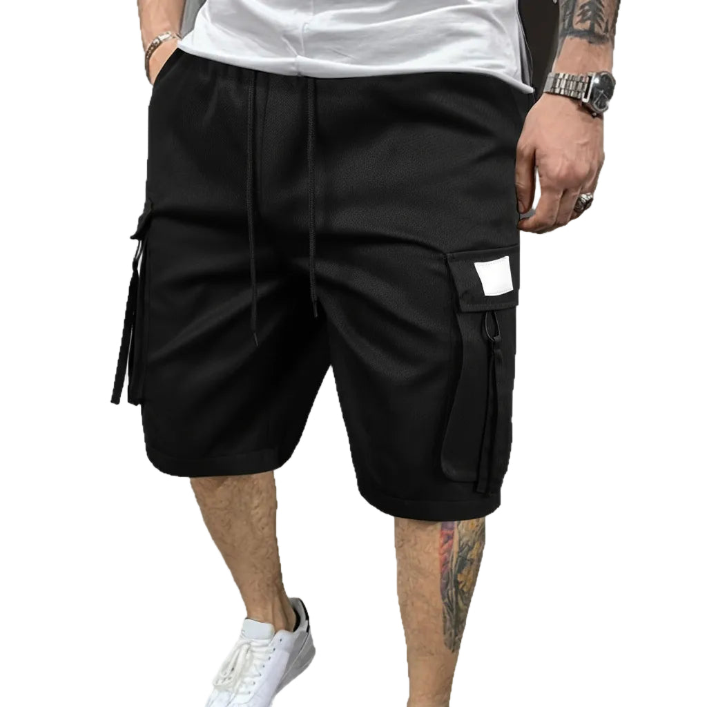 Black cargo shorts worn by a person on a white background